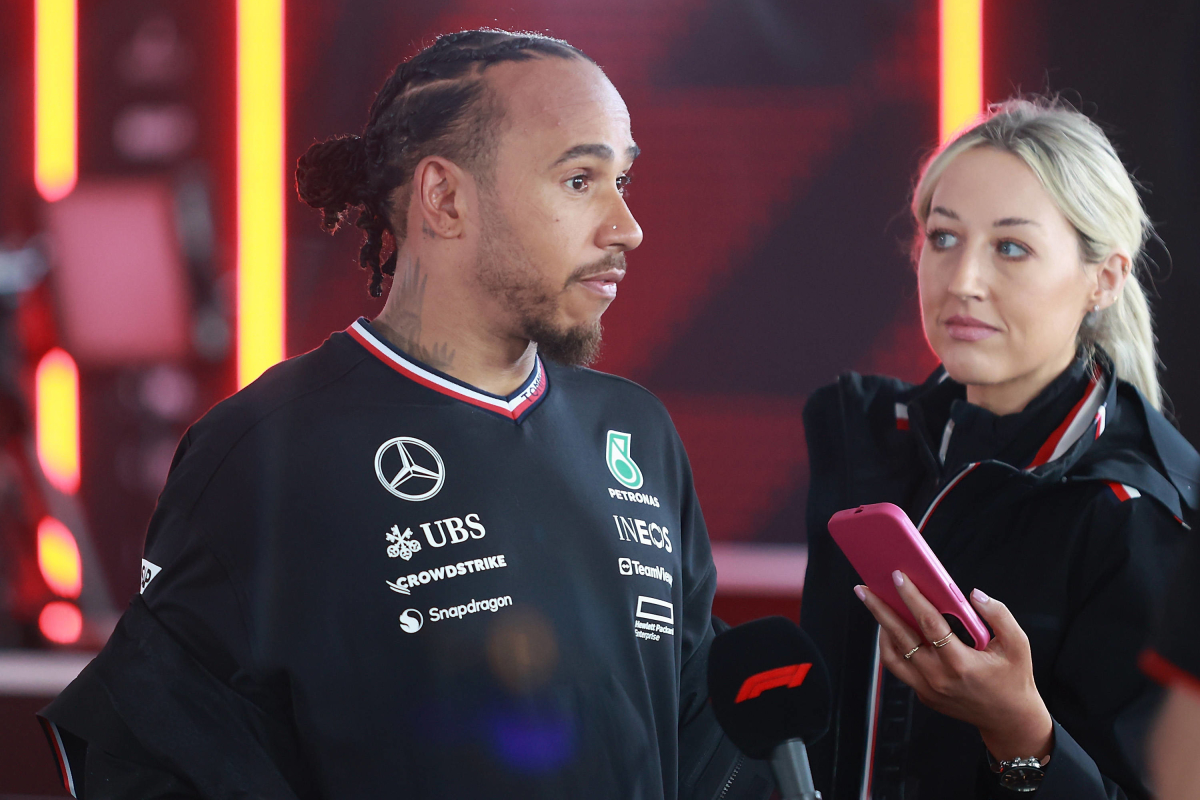 Who is the woman with the pink phone by Lewis Hamilton's side?